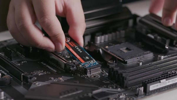 An NVMe SSD being slotted into a motherboard. These slim drives connect directly to your computer’s fastest ports, delivering blazing-fast speeds.